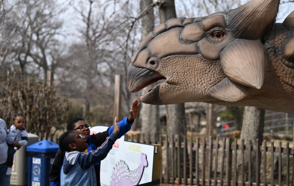 children touching the dino don robotic dinosaur