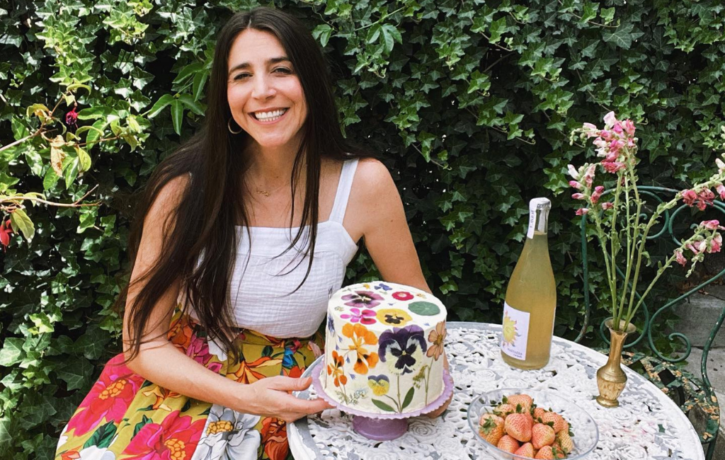 a woman with eat your flowers cake