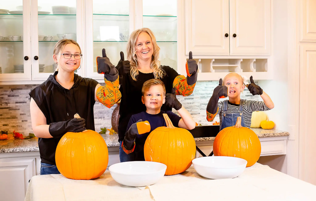 a family usinghalloween moments pumpkin scraper gloves