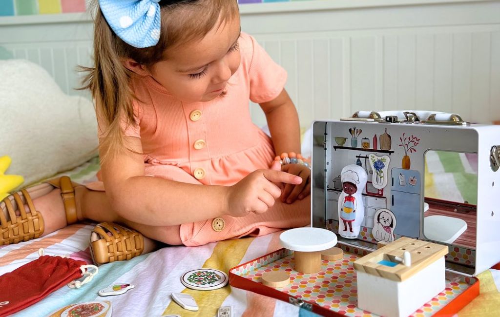 a girl playing with play maysie portable dollhouse