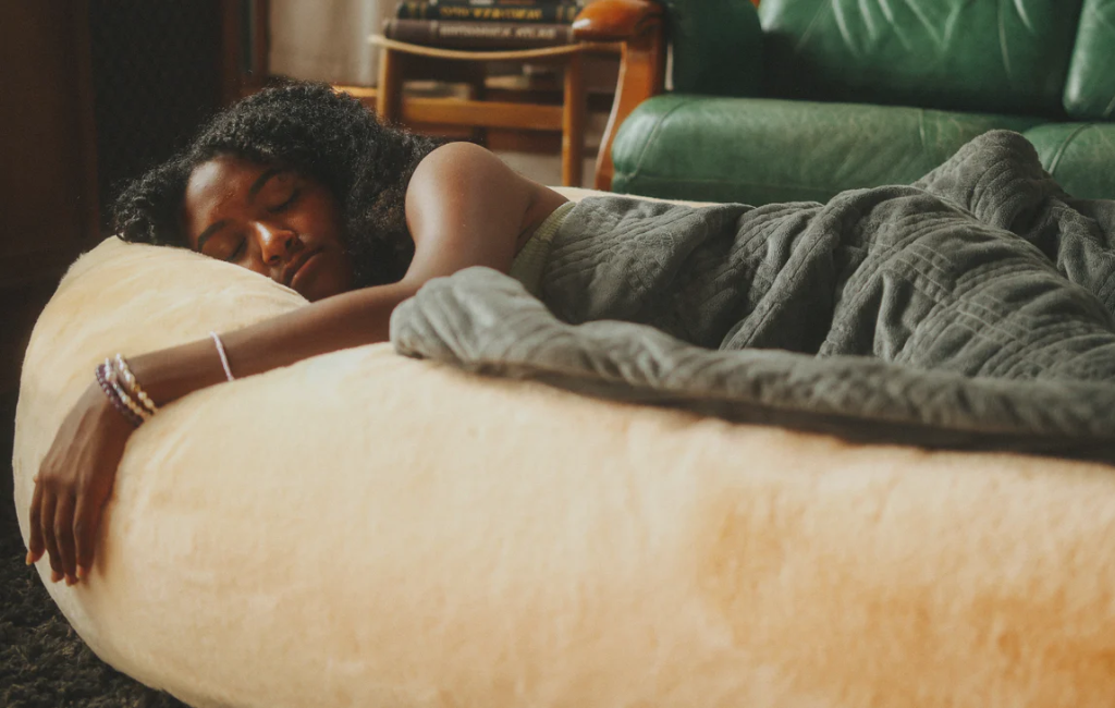 a girl sleeping on plufl human dog bed