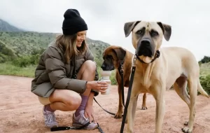 woman giving water to dog